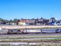 CN 8512 is moving VIA 6911 and what is possibly her train in Toronto on August 25, 1984.