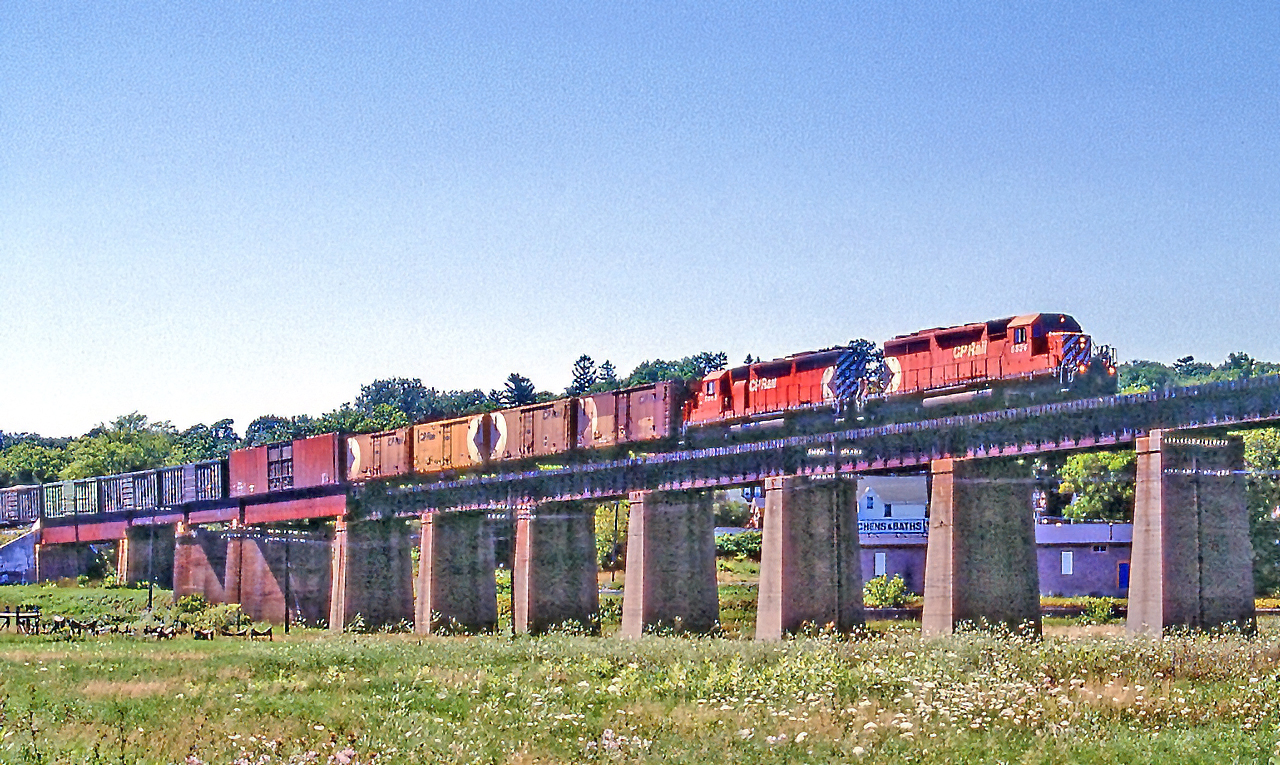 CP 5534 is on the bridge over the Ganaraska River in Port Hope, Ontario on August 6, 1987.