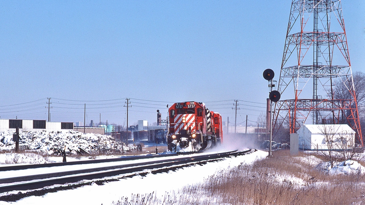 Approach the Leaside crossover,


  White Flags denote CP Rail 5737 Extra West,


  The Phone Box at left is for the CN Leaside Branch lead (ex CNoR)    


    CNR retained the CNoR  north track rights on the CPR Belleville Sub from Donlands mile 204.6 to near the  Wickstead Ave level crossing mile 205.44 (junction service track to the  CN Leaside branch), 


for CN crews 'Movements between Donlands and Wickstead Ave will be governed by CP Rail time table' 


The signal on that gantry to the left of 5737's cab protects CP Rail  eastbound movements for the service track switch (points facing east)  connecting to the CP Rail north main track.


CP Rail 5737 is west of the Wickstead level crossing, March 2, 1980 Kodachrome by S.Danko.


More


  Big M's  


sdfourty