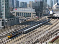 Back on Dan's model train layout of Union Station, circa 2007, we have VIA Rail train #60 departing eastbound from track 10 with a Rapido Trains DCC/Sound F40PH-2D 6412 and 5 stainless steel kitbashed Walthers HEP cars, waiting while VIA #53 with Athearn Genesis P42DC 918 arrives with four Rapido LRC cars in tow (the ones from the first run that roll like iron sleds) into track 9 under the train shed. As you can see, we maxed out our credit card buying all that Atlas flextrack and many, many PECO double throw slip switches (too many), and ballasting it all with Woodland Scenics products took forever.<br><br>There's some scratchbuilt buildings in the background including part of the Air Canada Centre (partially kitbashed from an old Bachmann post office kit), and our 3D-printed Skydome complete with working lights and dome action, fully open today for the miniature Blue Jays to win the Stanley Cup of Baseball. We got a good deal on Walthers Cornerstone cookie-cutter condos that were on deep discount at George's Trains when they closed their Mount Pleasant store (RIP 510 Mount Pleasant), so pretended we were a real estate developer and threw them in wherever there was some bare layout showing, blocking out Lake Ontario so we didn't have to scenic it (still need to add more condos in the future, might remove some other buildings from the layout here to make space). Our Bay Street parking lot was populated with a selection of late-model HO-scale Brenka and Walthers cars for the afternoon (good spot for a future condo, hmmmm). That old brown building to the left of the ACC is the former OPP headquarters, that I think I picked up at a swap-meet for 5 bucks off a used table (might replace that with condos too). Our layout lighting however, has the unfortunate effect of always being at the wrong angle for shooting from this side of the aisle. Oh, that billboard ad was cut out from the Sears catalogue and glued on a used Walthers billboard found at a Brampton train show, it previously had an ad for some company called Nortel.<br><br>Future updates include some Bachmann VIA Siemens Charger trainsets and a Northlander, many more condos, a little train museum somewhere nearby for the relics and inoperable models, yet more condos, and I may have to cut a giant hole in my train shed to put a large plexiglass ice cube on top. We won't run freights down here anymore since <i>someone<i> recently derailed their CN #435 over at Mimico and no GO trains could get out of the staging yard, messing up our entire operating session that one afternoon...