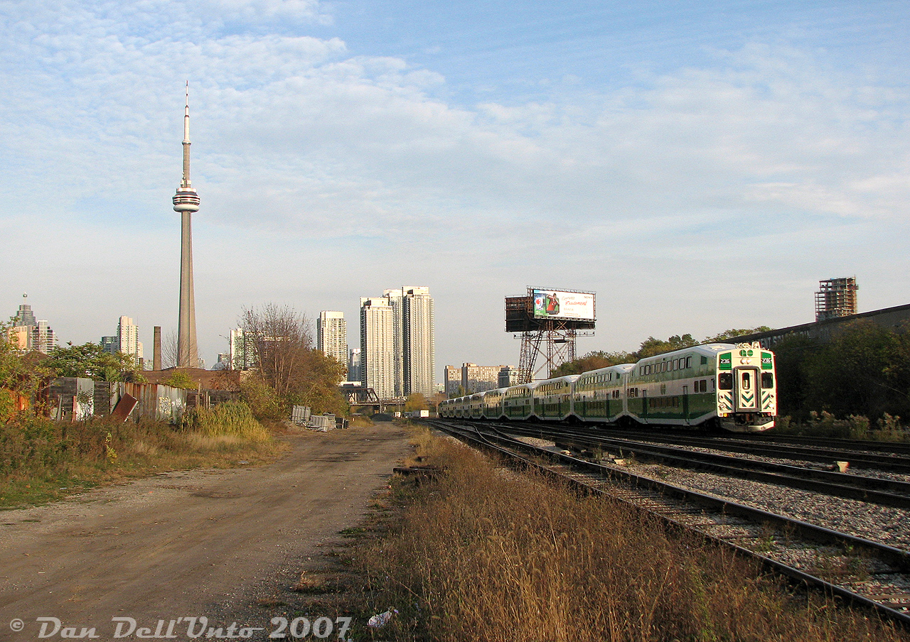 You've seen the view from aboard the train, now here's the view from on the ground: Milton-line GO train #153 lead by cab car 236 (with F59PH 556 pushing leisurely on the rear) rocks through the crossovers at 30mph as it approaches the Strachan Avenue grade crossing in Liberty Village, about to exit the western USRC limits and enter CP's Galt Sub.

Wandering into the Strachan Avenue area of Liberty Village/Parkdale in the late 2000's felt like entering a de-industrialized wasteland of hollowed-out post-industrial decay. A large multi-track grade crossing one could just wander into, set amid an area with old warehouses and factories waiting to be torn down and redeveloped, including such welcoming landmarks as the Wellington Destructor garbage incinerator (note brown building with smokestack on left), the Toronto Abbatoir slaughterhouse next to it (still in operation at the time), the old Canadian Patent Scaffolding building (occupied by some used office furniture business), the old police garage(?) on Ordnance St. all closed up, and the John B. Smith building (out of frame on the left) complete with that mismatched wall of old doors. All the former freight yards and sidings had been pulled up long ago. Modern progress looming in the background as the wall of downtown condos encroached. Soon Liberty Village, still in the process of gentrification at the time with many old buildings demolished or converted to trendy lofts, would start getting many new condos of its own, and sweep more of its industrial past away.

This last vestige of easy rail access that hosted a flurry of GO and VIA activity every rush hour (multiple Bradford, Georgetown and Milton line trains, and six daily VIA corridor trains to Sarnia) would become a giant hole in the ground a few years later, with the grade separation tunnel making it near impossible to shoot at Strachan Avenue anymore (but the nearby pedestrian bridges offers a few possibilities from above).