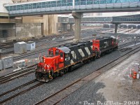 "That's not a GO Train!"<br><br>After finishing their morning switching duties in the east end (likely around the Don Yard/Portlands/harbourfront area), CN local #543 with GP9RM's 4112 and 7007 cruises through the Union Station Rail Corridor past Toronto Union Station in the January rain, returning to Mimico Yard as light power. This local job, originating at Mimico, would often head east past Union in the morning, finish its switching, then come back west in the late morning or early afternoon when GO and VIA passenger traffic was lightest.<br><br>Two GP9RM units were standard fare at the time, as the fleet was still plentiful and in good health. The same pair would still be together <a href=http://www.railpictures.ca/?attachment_id=851><b>working #543 next month</b></a>, with a bit more snow on the ground.