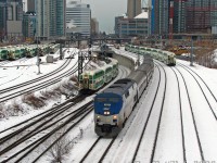 Even a cold winter's morning on Bathurst Street bridge never disappoints: three trains at once approach with Amtrak P42DC 103 leading the daily joint VIA-Amtrak #97 "The Maple Leaf" out of downtown Toronto (departure time 8:30am from Union), while GO cab car 237 leads westbound equipment move #456 (off morning Lakeshore East train #425 deadheading to Oakville to enter service as #456 back to Union, with F59PH 561 pushing) out of the flyunder, with red marker lights errantly left on. GO cab car 232 takes the high line with equipment move #270 (Georgetown line, Bramalea-Union only, with F59PH 522 pushing) westbound back to Willowbrook. Since it's just past 8:30am, GO's Bathurst North Yard is almost full of trains laying over after their morning runs, with the rest deadheading to Willowbrook for their afternoon layovers.<br><br>In the distance are more goodies that have passed minutes earlier: Ontario Northland GP38-2 1802 with F-unit generator car 204 and four single-level Hawkers advancing on Union Station for the regular morning "Northlander" train #697, following right behind the nose of VIA F40PH-2 6417 with three HEP cars on #85's equipment move, backing to Union Station from the TMC a few hours before its late-morning departure. We shot all that stuff inbound on the other side of the bridge, and with little time to spare, quickly jaywalked morning traffic to line up our shot of The Maple Leaf departing.<br><br>Also worth noting is part of York Excavating (now York 1)'s fleet of old "yellow iron" Caterpillar 225, 235 and 245 excavators working on the CityPlace condo development, built on the vacant "railway lands" (former CN Spadina Coachyard). A couple more condos have since been added to the view here...