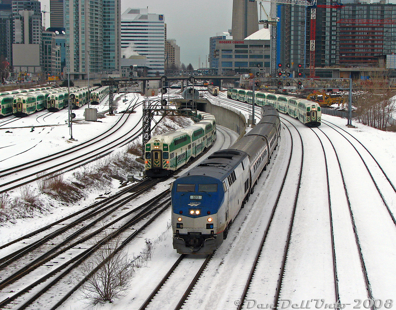 Even a cold winter's morning on Bathurst Street bridge never disappoints: three trains at once approach with Amtrak P42DC 103 leading the daily joint VIA-Amtrak #97 "The Maple Leaf" out of downtown Toronto (departure time 8:30am from Union), while GO cab car 237 leads westbound equipment move #456 (off a morning Lakeshore East run, with F59PH 561 pushing) out of the flyunder and back to Willowbrook, with red marker lights errantly left on. GO cab car 232 takes the high line with equipment move #270 (Georgetown line, Bramalea-Union only, with F59PH 522 pushing) westbound back to Willowbrook. Since it's just past 8:30am, GO's Bathurst North Yard is almost full of trains laying over after their morning runs, with the rest deadheading to Willowbrook for their afternoon layovers.

In the distance are more goodies that have passed minutes earlier: Ontario Northland GP38-2 1802 with F-unit generator car 204 and four single-level Hawkers advancing on Union Station for the regular morning "Northlander" train #697, following right behind the nose of VIA F40PH-2 6417 with three HEP cars on #85's equipment move, backing to Union Station from the TMC a few hours before its late-morning departure. We shot all that stuff inbound on the other side of the bridge, and quickly jaywalked morning traffic to line up our shot of The Maple Leaf departing.

Also worth noting is part of York Excavating (now York 1)'s fleet of old "yellow iron" Caterpillar 225, 235 and 245 excavators working on the CityPlace condo development, built on the vacant "railway lands" (former CN Spadina Coachyard). A couple more condos have since been added to the view here...