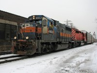 Rough unit in a rough hood. You never know who or what might show up down by the train tracks in some parts of Toronto, in this case a ratty and well-worn CP GP40-2 4652 rolls through Bartlett Avenue crossing on the North Toronto Sub with SD40-2 6030, working train #T56, the transfer from Toronto (Agincourt) Yard to West Toronto/Lambton Yards. The conductor on this day, known in some circles as "oeuf", is wearing his signature Pink Floyd touque as he leans out of his trusty steed, having just generously contributed/chucked a document-wrapped water bottle to the bystanders and miscreants trackside. He later expressed great preference and fondness for this "greasy" set of power, despite its outward rat-rod appearance.<br><br>When CP purchased these eight former Guilford GP40-2 units from Helm Leasing (<a href=https://cptdb.ca/wiki/index.php?title=Canadian_Pacific_Railway_4650-4657><b>4650-4657</b></a>), they weren't too quick to repaint them, and some got fresh <a href=http://www.railpictures.ca/?attachment_id=31816><b>red paint</b></a> while others continued to run in <a href=http://www.railpictures.ca/?attachment_id=46987><b>patched fading Guilford grey/orange</b></a> for years, some so long that the original B&M blue started showing through. Apparently as the story goes, the guys down on the former D&H got so sick of seeing the Guilford paint on these units (bad memories from the D&H's Guilford era?) that they roller-brushed 4650 and 4653 red themselves and applied non-standard lettering. 4652 wasn't so fortunate, and the unit continued to run around the Toronto and Ontario area eluding the paint shop as the unofficial <a href=http://www.railpictures.ca/?attachment_id=8161><b>"Guilford heritage unit"</b></a> (even causing a large wreck on the Belleville Sub in 2009) until it was finally sidelined and retired (since sold to Northern Plains RR, maybe they'll paint it someday). 