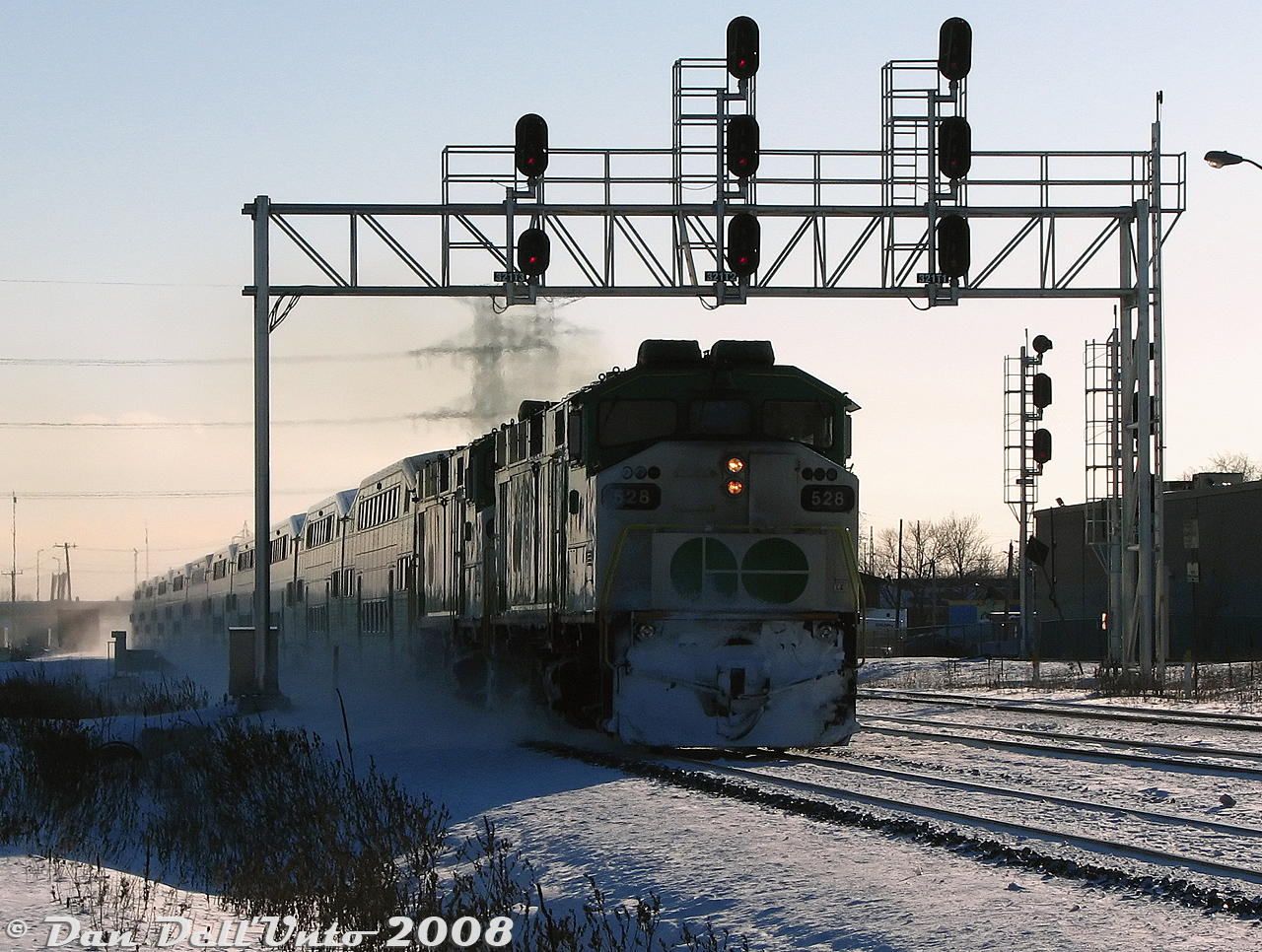 Working the weekend shift on a frigid winter's day, double GO Transit F59PH's 528 and 543 hustle eastbound Lakeshore line train #924 through Burlington West at last light, kicking up a trail of snow as they bear down on their next stop at Burlington GO Station.I was told at the time by a source that the twin F59's assigned to many weekend Lakeshore lines trains were not because of reliability issues, but for better acceleration and weekend schedule adherence (6000 horsepower does get the train moving faster than 3000 horsepower). 528 would get sold to Trinity Railway Express the next year, and 543 to AMT in 2011 (only to be later bought back by GO as 582).