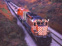 Crisp fall day along the CN Oakville sub near a location now known as 'Snake'. CP 5528 leads an unknown MLW in the image shot from what I refer to as the 'Cemetery Bridge', just east of the Bayview's Laking Gardens where all the fans hang out.
Don't know for sure, so I just assume this  train is the 'Starlite" heading for Hamilton's Aberdeen yard.
Note the old brick company chimney in the background. And a relic of the past, that triangular 'Junction 1 mile' sign on the left. Back in those days there were a number of them around, but now, all gone. Not even in anyone's collections that I know of.