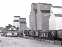 At the very north end of CN’s Athabasca subdivision (originally Canadian Northern’s subsidiary Edmonton & Slave Lake) was the town of Athabasca, on the south side of the Athabasca River.  A turn from Edmonton on Sunday 1980-09-21 with branchline GMD1s CN 1008 + 1007 +1009 brought empties for loading at the several grain elevators, and as seen here, collected a train of loads to take back southward.  That depot was then occupied by the Athabasca District Senior Citizens Society, and survives to this day administered by the Athabasca Heritage Society.
