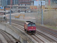 What is this stray VIA F40PH? What is it doing here? Why, it's the morning "Drop Unit" off VIA #40-52, making its way out of the Union Station back to the Toronto Maintenance Centre in Mimico. Today, CBC Radio-Canada wrapped VIA 6403 was doing the honors, captured heading westbound at Bathurst Street bridge exiting the USRC after its morning duties were complete. One of the regular York Excavating Cat 235C's works in the background on the CityPlace condo development.<br><br>This unit was originally part of VIA "J-Train" #40-52's consist. Every day, a spare F40PH would couple up to the rear of that combined train to lead it from the TMC to Aldershot, then the train would change directions and run in service from Aldershot (6:00am) to Toronto Union Station (arriving 6:35am) with the F40 in tow, where it would make its station stop and drop this unit off the tail end before departing (6:55am) east out of Union and on to Brockville (doing the split for Ottawa/Montreal there). That train was an early morning arrival/departure into Union that I never caught arriving (and caught departing only once), but I did catch their stray F40.<br><br>Another one of those morning eccentricities to look forward to at Bathurst Street, this thing would show up sometime before the height of morning rush hour, going against all the inbound traffic to make it back upstream to the TMC in Mimico. It was on the morning "hit list", but would usually depart Union around 7:30am so the lighting wasn't the best (and it couldn't be shot well in the darker months). Not entirely sure if VIA continues with this practice today, and not entirely sure how many people actually shot this early move, but a solo F40 passing through every morning was an odd sight.