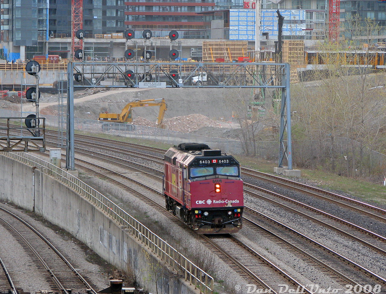 What is this stray VIA F40PH? What is it doing here? Why, it's the morning "Drop Unit" off VIA #40-52, making its way out of the Union Station back to the Toronto Maintenance Centre in Mimico. Today, CBC Radio-Canada wrapped VIA 6403 was doing the honors, captured heading westbound at Bathurst exiting the USRC after its morning duties were complete. One of the regular York Excavating Cat 235C's works in the background on the CityPlace condo development.

This unit was originally part of VIA "J-Train" #40-52's consist. Every day, a spare F40PH would couple up to the rear of that combined train to lead it from the TMC to Aldershot, then the train would change directions and run in service from Aldershot (6:00am) to Toronto Union Station (arriving 6:35am) with the F40 in tow, where it would make its station stop and drop this unit off the tail end before departing (6:55am) east out of Union and on to Brockville (doing the split for Ottawa/Montreal there). That train was an early morning arrival/departure into Union that I never caught arriving (and caught departing only once), but I did catch their stray F40.

Another one of those morning eccentricities to look forward to at Bathurst Street, this thing would show up sometime before the height of morning rush hour, going against all the inbound traffic to make it back upstream to the TMC in Mimico. It was on the morning "hit list", but would usually depart Union around 7:30am so the lighting wasn't the best (and it couldn't be shot well in the darker months). Not entirely sure if VIA continues with this practice today, and not entirely sure how many people actually shot this early move, but a solo F40 passing through every morning was an odd sight.