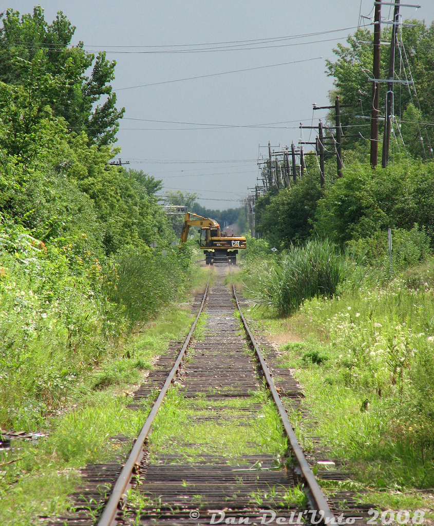 One for the "We went to get some OBRY and all we got was this hi-rail" files. Can't win 'em all: this Caterpillar M318 mobile excavator with hi-rail equipment was doing some track maintenance along the Orangeville-Brampton Railway in Brampton with its brush-cutter head attachment, seen making its way south/west between McMurchy and McLaughlin (approaching McLaughlin grade crossing) leaving a somewhat more cut-back right-of-way in its wake (still better than anything you'll see on the OBRY today, thanks to Orangeville city council...).