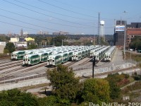 Afternoon layover at GO Transit's Don Yard east of Union Station shows multiple 10- and 12-car train consists awaiting their call to PM rush hour service in a few hours. Cab cars visible from left to right are 216, 202(?), 2??, 236, 206(?), 250, 209, 251, 204, and 237, with various MP40 and F59 units on the other ends.<br><br>Don Yard used to be an old CN freight yard for the longest time, dating back to the steam era, until it was taken over by GO Transit around 2006-07 and converted to store GO trains on layover (like <a href=http://www.railpictures.ca/?attachment_id=55592><b>Bathurst North Yard</b></a> years earlier). The track running along the bottom of the retaining wall was the spur from the Union Station Rail Corridor to the Toronto Harbour Commission trackage in the Toronto portlands (Eastern Harbour Terminals) including Keating Yard at the foot of the Don Roadway, the Toronto Port Authority, the Ashbridges Bay Wastewater Treatment Plant, and to the old Wilson Yard (a small storage yard just south of Don Yard). All of that trackage has since been removed after rail service to the portlands was discontinued (last run in 2018).<br><br>The CN Bala Sub can be seen curving up the Don Valley to the north off the USRC (above the leftmost cab car), and the CN Kingston Sub curving off in the distance beyond the signal bridge. The large building on the right with the water tower is the old Lever Brothers/Unilever/Korex soap plant (once had rail service, but recently closed for good in August 2009 after the company declared bankruptcy during to a labour disruption that started in 2008). The two old red buildings beyond that are from the old Consumers Gas Station B coal gas manufacturing facility that was once around Eastern Ave & Booth (they once had multiple sidings and rail service too). Some apartments in East York are visible in the distance above the foliage canopy  (possibly around Victoria Park/Dawes Rd).<br><br>This was a rather difficult shot to get at the time, as in 2009 we weren't blessed with the abundance of cheap commercially available drones, there were no condos, bridges or overpasses nearby to shoot from, stopping here in a lane of speeding traffic was not advised, and you couldn't exactly walk up the side of the Gardiner Expressway to this spot without quickly being branded a looney and getting a wellness visit from a few Crown Vics ("Yes officer, I'll come down peacefully, I just need to shoot the GO trains in the train yard first"). The side barriers and guardrails also blocked this view from most cars. But a ride bouncing around at the back of a GO D4500 commuter coach on the Barrie-King City-Vaughan run (that only went down the Don Valley on certain days, at certain times, depending on certain operators) gave just enough elevation to snap a photo looking backwards and get all of Don Yard in view. I remember sending it to the late Ray Kennedy (<a href=https://www.trainweb.us/oldtimetrains/><b>OldTimeTrains</b></a>) at the time, and he seemed quite impressed I was able to get a shot of the new GO yard from this angle.