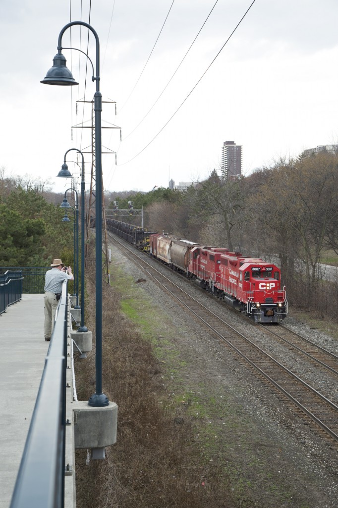 An eastbound CWR work train loaded with ribbon rail cruises eastbound through the neighbourhood. Not sure if this was a work train for the Galt, Mactier, or Belleville Subs. Big points for the cylindrical hoppers for buffers. This consist had a work van on the tail end to boot.