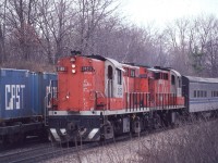 A westbound CN Tempo train for Windsor, Ontario creeps by a stopped train with some CAST containers at Bayview Junction on April 12, 1981.