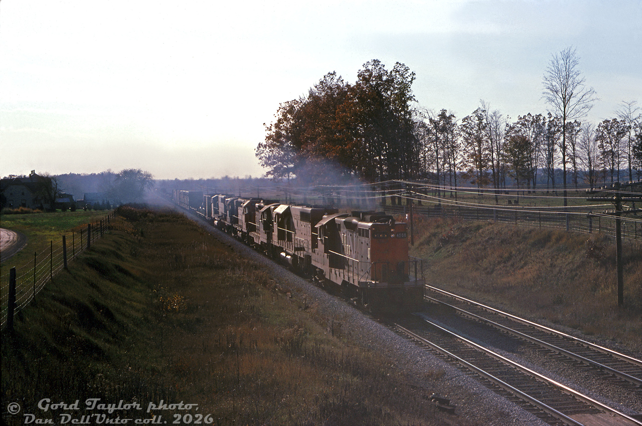 Leaving a trail of diesel exhaust in its wake, a CN freight rolls into London with GP9 4566 leads a mixed-bag lashup of an SD40, GP9, GP40, RS18 and GP40-2LW, heading eastbound through Hyde Park on the Strathroy Sub.

Gord Taylor photo, Dan Dell'Unto collection slide.