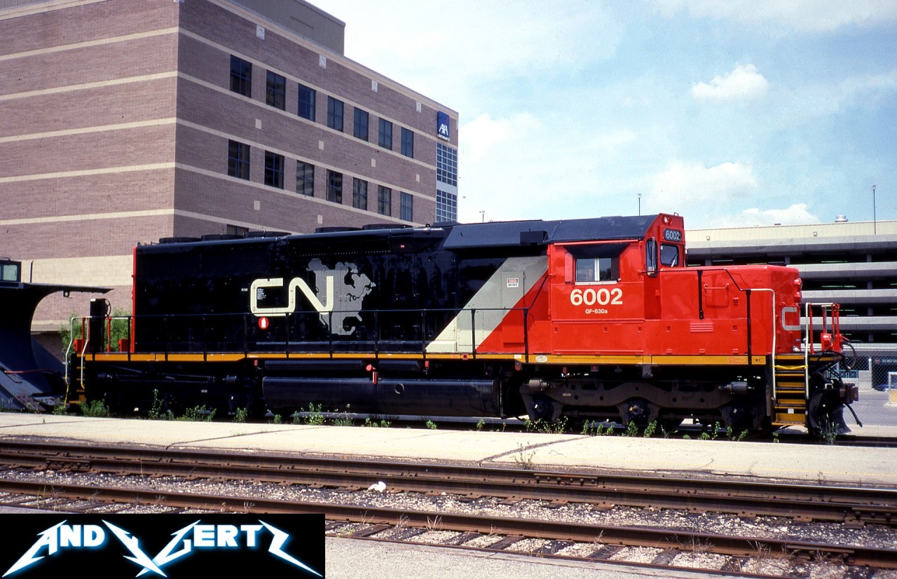 Still fresh CN SD40u 6002 is pictured on display in downtown London, Ontario in June 1993 to celebrate the city’s bicentennial of transportation. The recently rebuilt unit was on display with brand new Conrail SD60M 5564, which had just rolled out of London’s GMDD plant, located only a few miles away. Also, on exhibition for the event were black CN plow 55614, two VIA Rail 5500-series coaches and a CP 85000-series boxcar.

SD40u 6002 was originally built as CN SD40 5118 during 1969 at the GMDD plant in London and was eventually remanufactured by AMF in Montreal and released on January 26, 1993. Many years later, both it and sister SD40u 6004 were severely damaged in a wreck at Alix Junction, Alberta in May 2007 and subsequently retired.