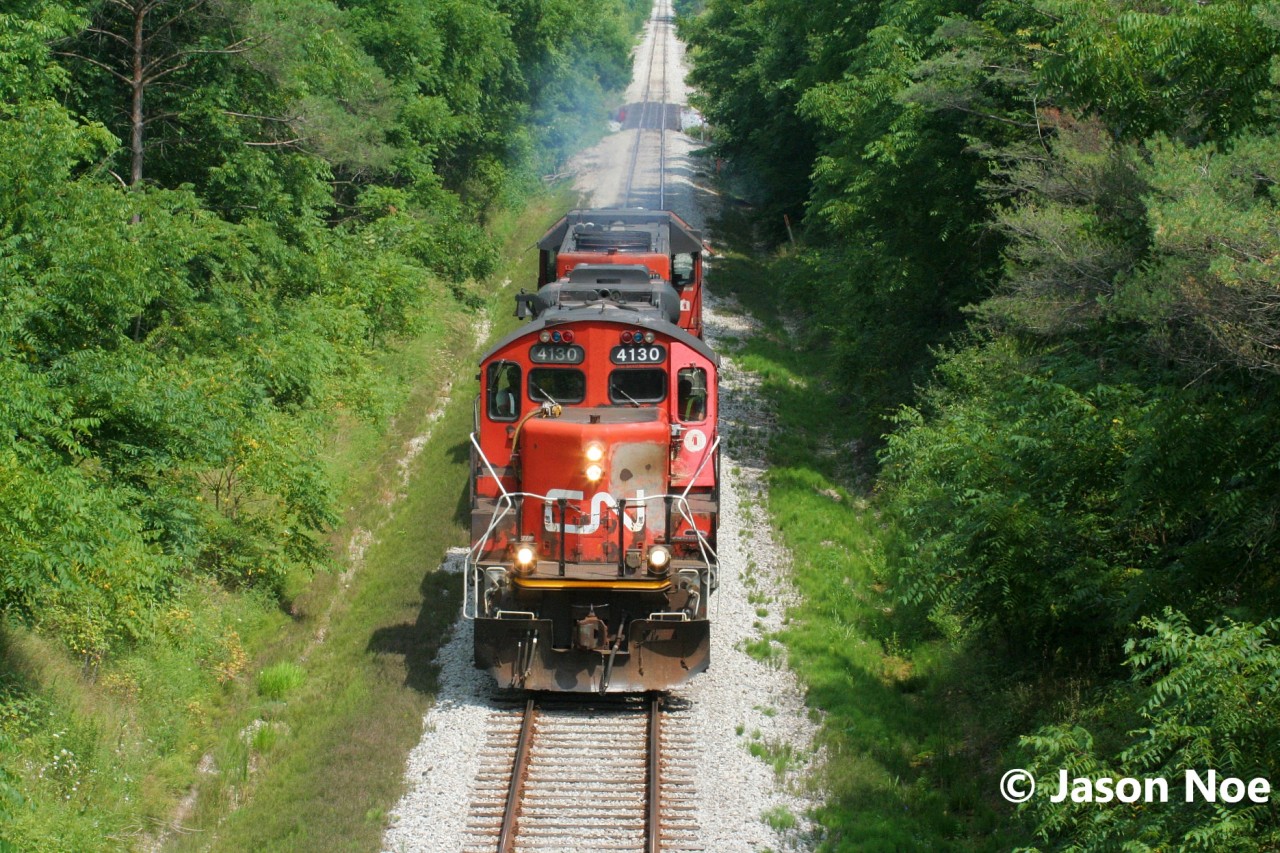 On a summer afternoon, CN L568 is viewed just west of New Hamburg, Ontario as it heads to Stratford on the CN Guelph Subdivision with GP9RM 4130 and GP38-2 4716 light power.