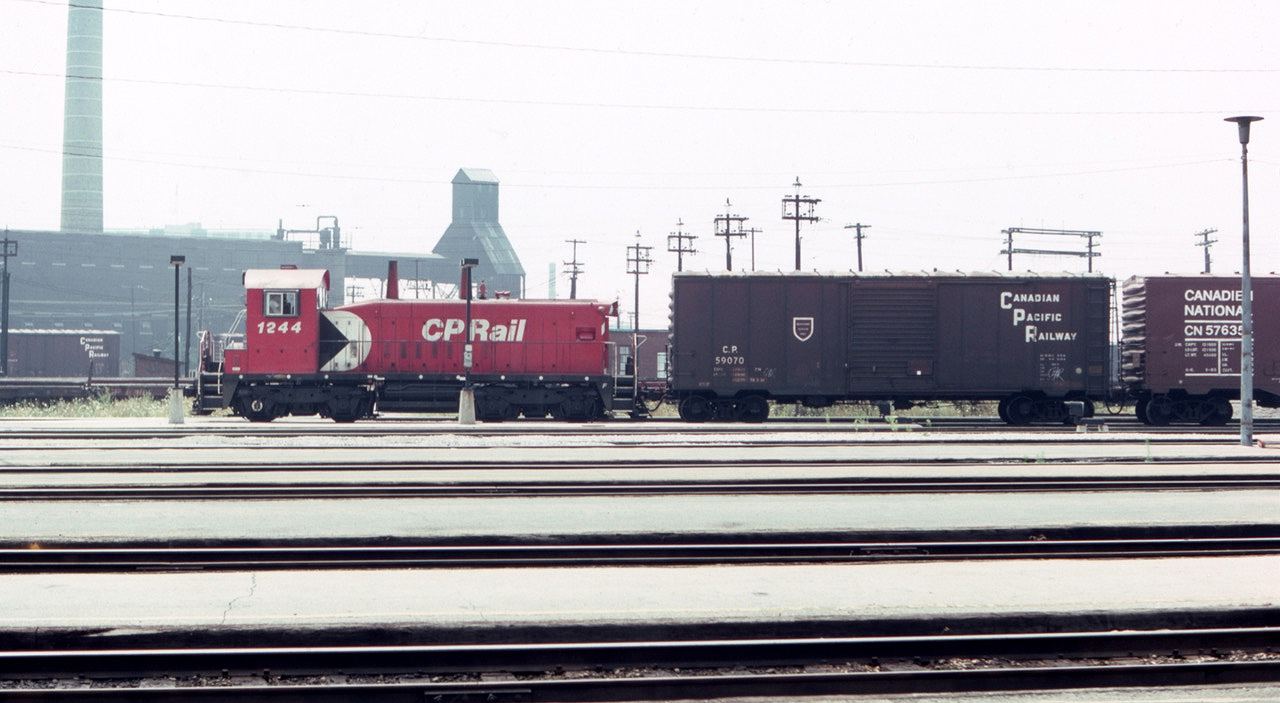 Toronto Union Station has plenty of passenger action, but on a hot hazy day in August of 1983, CP switcher 1244 passed by the south side of the station with a yard job, including old timer boxcar CP 59070. The internet claims that the unit had been rebuilt in 1982.