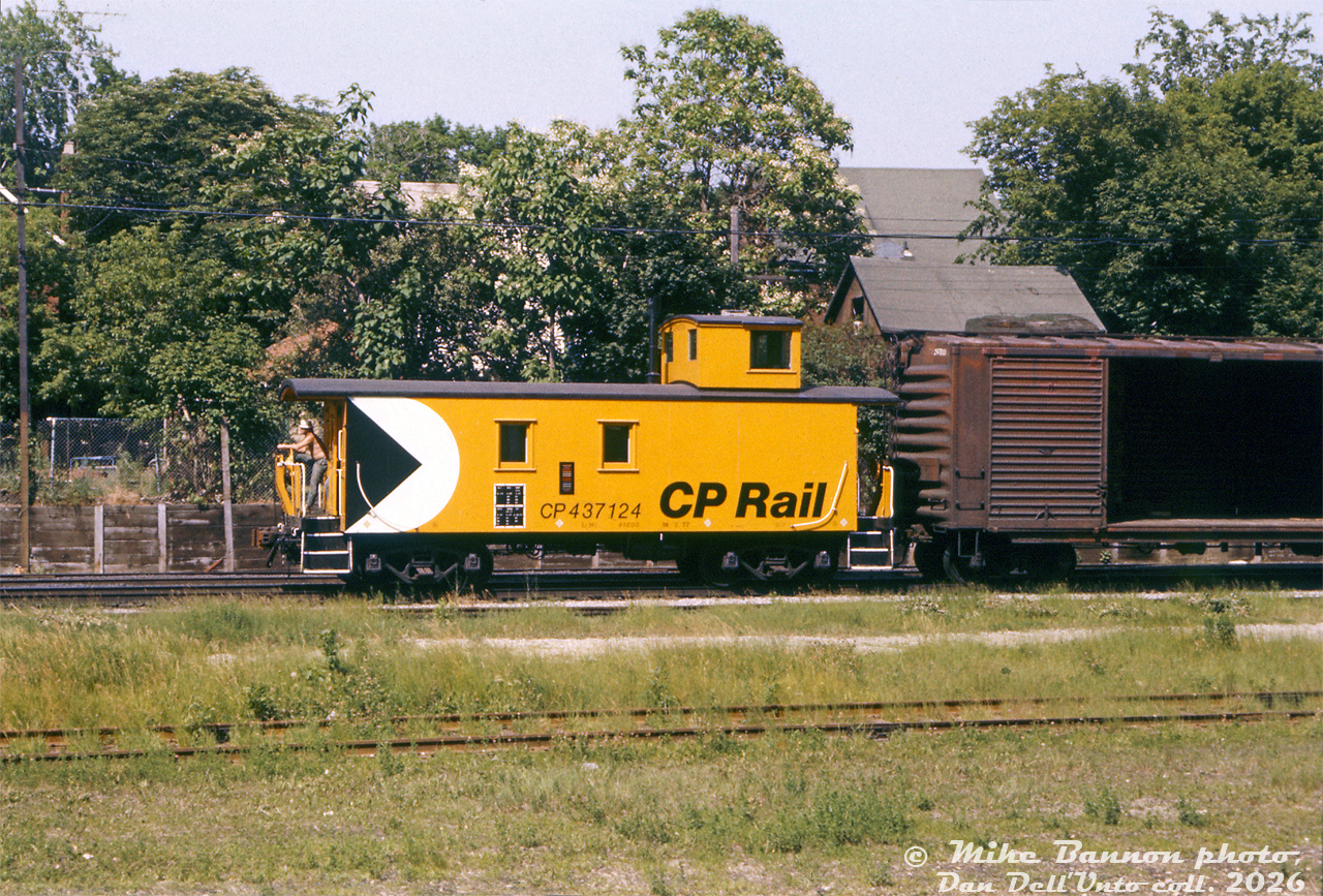 Very fresh looking CP Rail wooden caboose 437124 (a "van" in CP parlance) tags along on the rear of a CP local freight passing through the Weston area of Toronto on CP's MacTier Sub. With a crewmember riding the rear porch, it's unclear if it's trailing the train or leading on a backup move, but leading he'd need an air whistle hooked up to the trainline to signal for the crossings. That old CP 40' double door boxcar with both doors open may be enroute for spotting at a local customer. It's hard to place this shot, but it appears to be just south of King Street grade crossing, north of GO/CN's Weston Station.

The tracks through this corridor of Weston at the time included the two CP MacTier Sub mainlines, a CN-CP interchange track just in front of the caboose, a CN customs/bond/team/service track in the foreground, and CN's Weston Sub mainline along with a passing siding (both would be in the foreground at the bottom of this photo, out of frame).

Mike Bannon photo, Dan Dell'Unto collection slide.