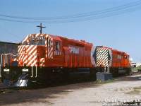 You can just smell the new paint! Brand new CP Rail SD40-2 units 5597 and 5598 sit in fresh spotless red, white and black "Action Red" livery at CP's Quebec Street Shops, newly outshopped from the nearby GMD London plant. Both feature the then-current large multimark and 5" full front cab and end striping. Note CP/Canadian-specific details including vertical steps and profiled handrails, nose-mounted headlight on early 81' short hood, numberboard-mounted brass bell, single class lights, nose brakewheel, CP-style rock pilot plow, Nathan Airchime K3LR2 horn, end pilot lift rings (no ditch lights for a few more years), and single rear headlight with no end numberboards. Red markings and chain keepers on the end MU hoses are a nice touch. Also of local interest is the roundhouse turntable near the Quebec Street overpass.<br><br>Both units were part of CP's second order for EMD/GMD's new SD40-2 model: GMD order C-349 for CP units 5589-5628, DRF-30h class, built May-July 1972. Both were outshopped at the same time, and (as per the Dean & Hanna CP book) officially added to the CP roster on May 19th 1972. 5598 was retired after an accident on the Ignace Sub in March 1979, while 5597 was retired in 2004 and sold to NRE (then resold to the Chicago, Fort Wayne & Eastern RR).<br><br><i>Gord Taylor photo, Dan Dell'Unto collection slide.</i>