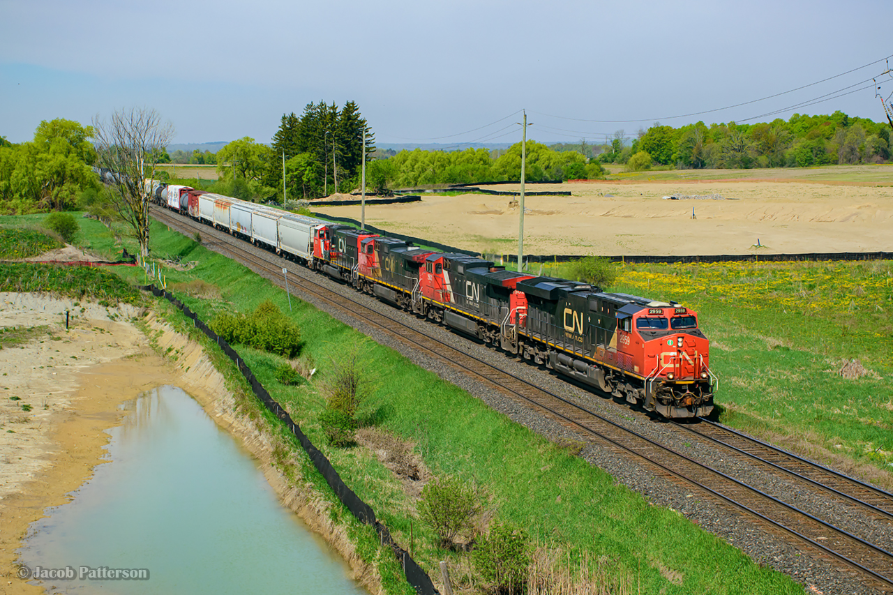 CN M396 is seen ducking beneath the new Mississauga Road overpass approaching the Norval crossovers.  The bridge recently opened during this past winter, replacing the grade crossing.