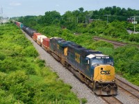 An SD70MAC leads on off schedule CN 326 eastbound on the Kingston Sub on Canada Day.