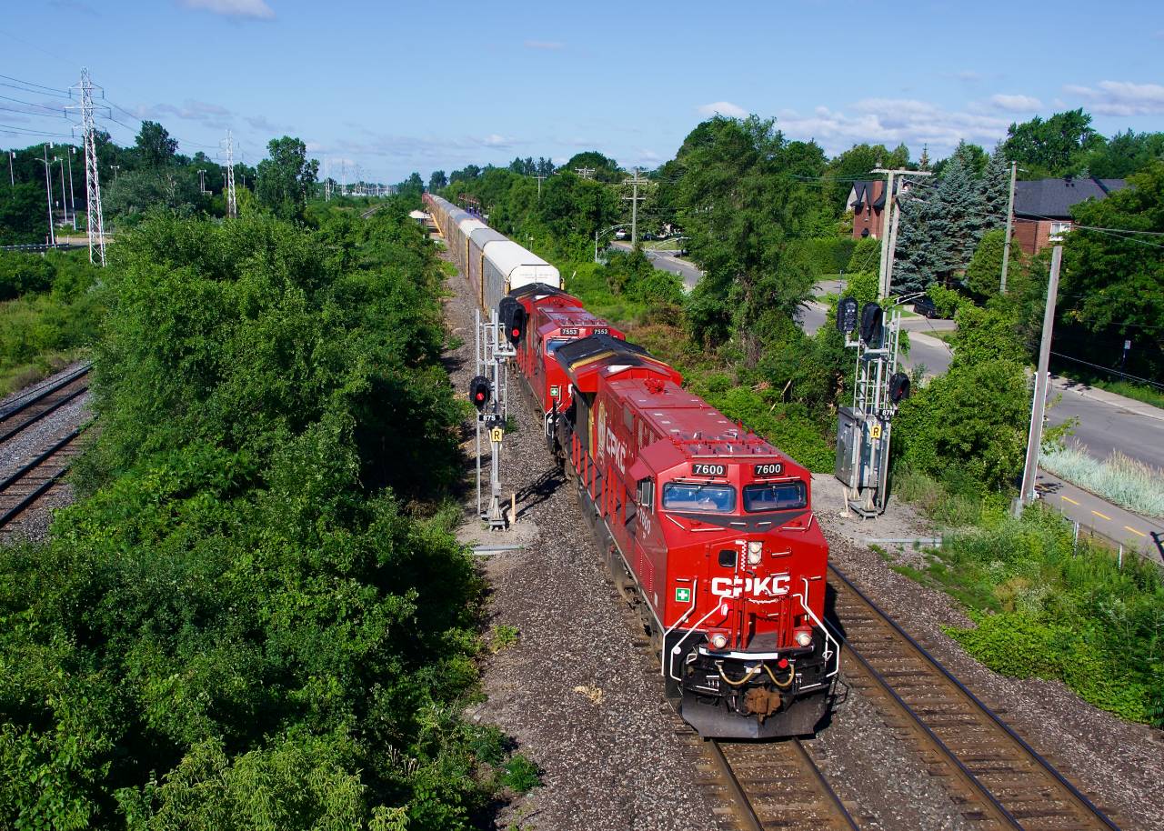 CPKC 230 splits the signals with new ET44ACs CP 7600 & CP 7553 for power and a lot of autoracks up front. Behind is some intermodal traffic and then a very small amount of mixed freight.