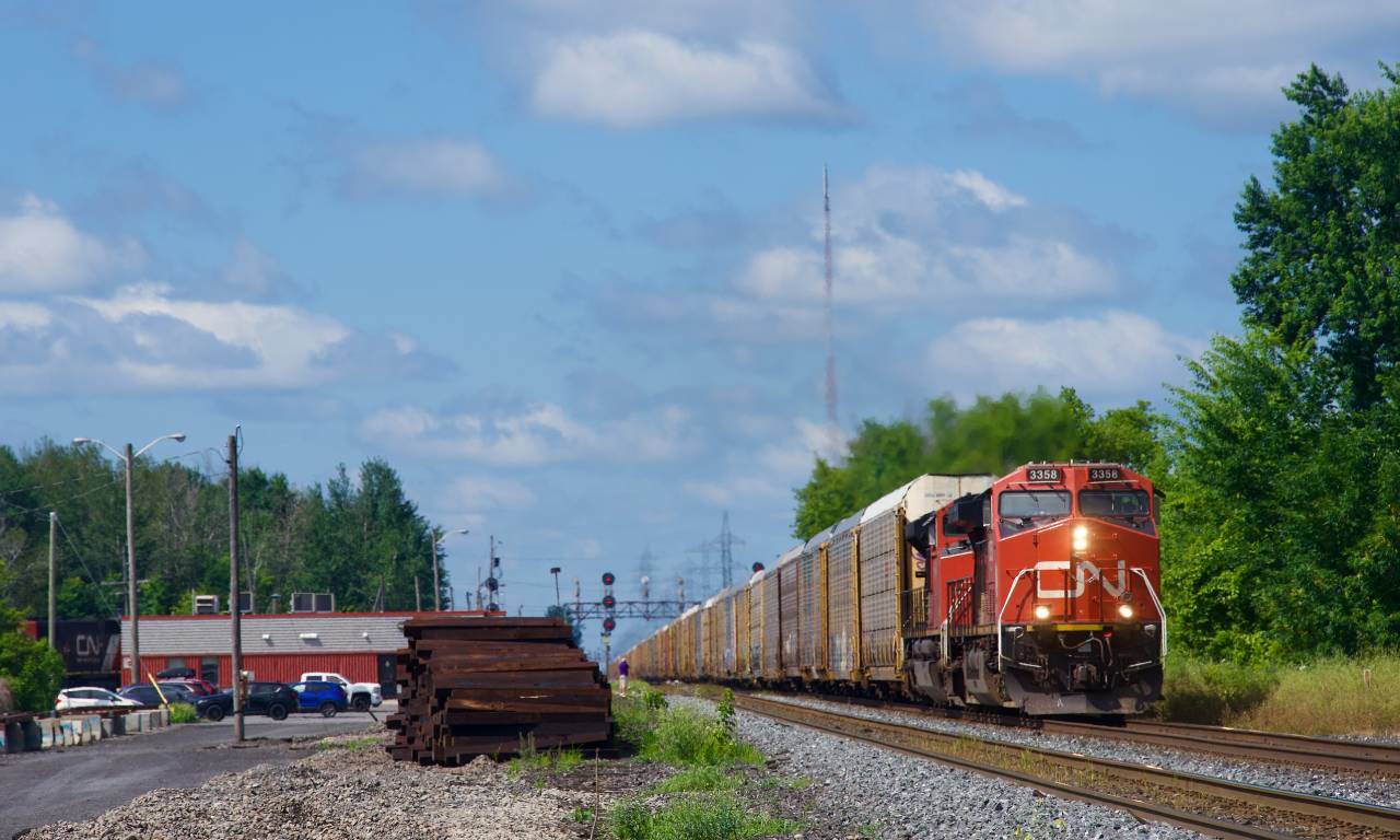 Hot on the heels of CN 368, CN 276 passes Coteau Station with CN 3358 leading. Barely visible behind the station is parked local power.