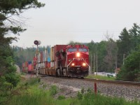 A northbound intermodal crosses Highway 26. CP recently rebuilt this road crossing. For about a week there was a nasty bump in the road as the rails were a couple of inches higher with a short ramp up. The approaches have been re-paved so things are smoother now.