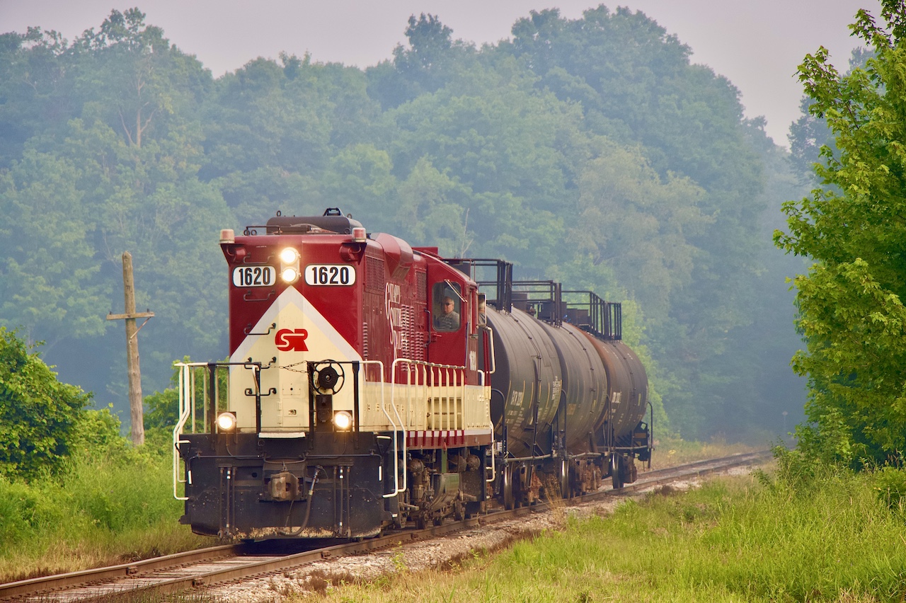 The forest fire smoke from northwestern Ontario is very visable thanks to shifting winds, as OSR’s job to Tilsonburg heads south just out of Salford, with three tank cars in tow. They will have over an hours work in Tilsonburg before heading back north.