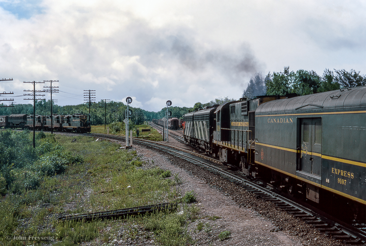 Turning around from the previous view, train 52, the Super Continental, is seen having just departed Washago, taking the Newmarket Sub towards Toronto.  At left, train 409 waits to continue to Capreol behind CN 4568, CN 4560, CN 4573.

Scan and editing by Jacob Patterson.