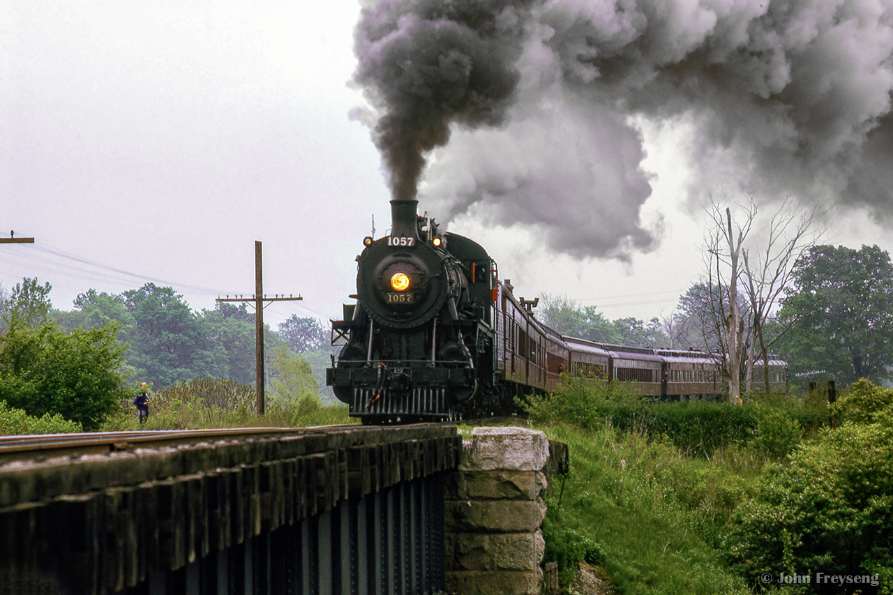 Making a runpast at the Credit River bridge in Mississauga's west end, Ontario Rail Association's Credit Valley Railway 1057 smokes it up during the northbound run to Orangeville and return as part of the City of Brampton's centennial celebrations.  Today, the Derry Road crossing is located roughly at the tail end of the train.

Scan and editing by Jacob Patterson.