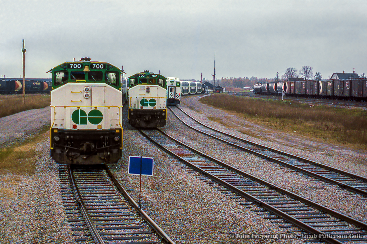 Looking back from the cab of the Guelph Junction road switcher, three GO Transit consists are viewed tied down at Guelph Junction awaiting their next runs to Toronto.  A GP40TC and two APCUs bring up the east end of the consists.

Departing for Waterdown North.

John Freyseng Photo, Jacob Patterson Collection Slide.