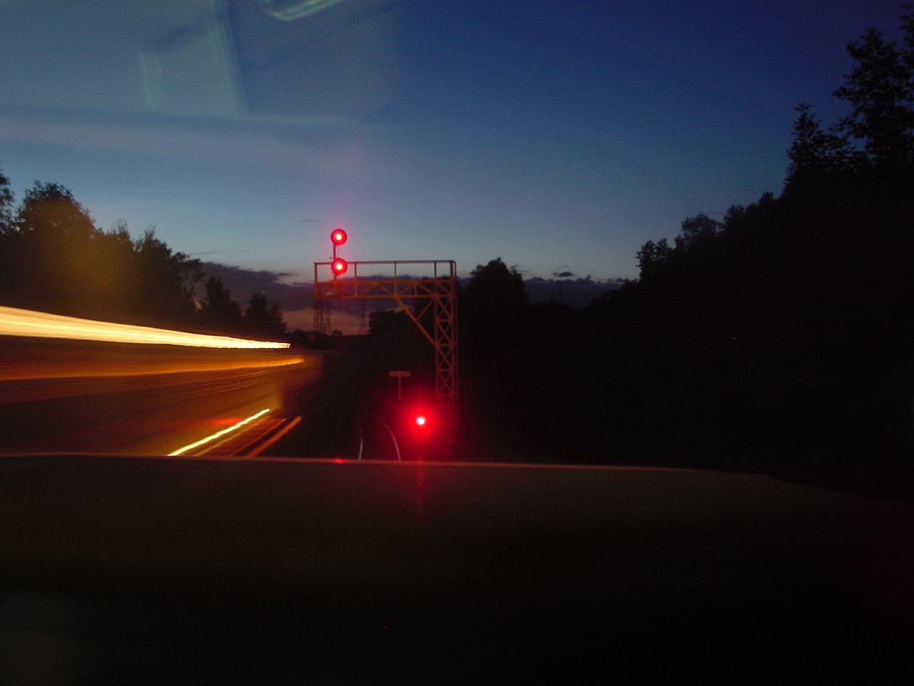 8/11/01 The summer sun has not even set at 8:21pm as my train is in the siding at Beare on CN's York Sub. The RTC put a lot of faith in me to get my train in the clear before the eastbound hotshot was on the approach to Beare. The RTC was very happy.
In front of my train is a dwarf signal displaying red and somehow I was able to catch the headlight of the eastbound train as it moves under the bridge carrying CP's Belleville Sub.