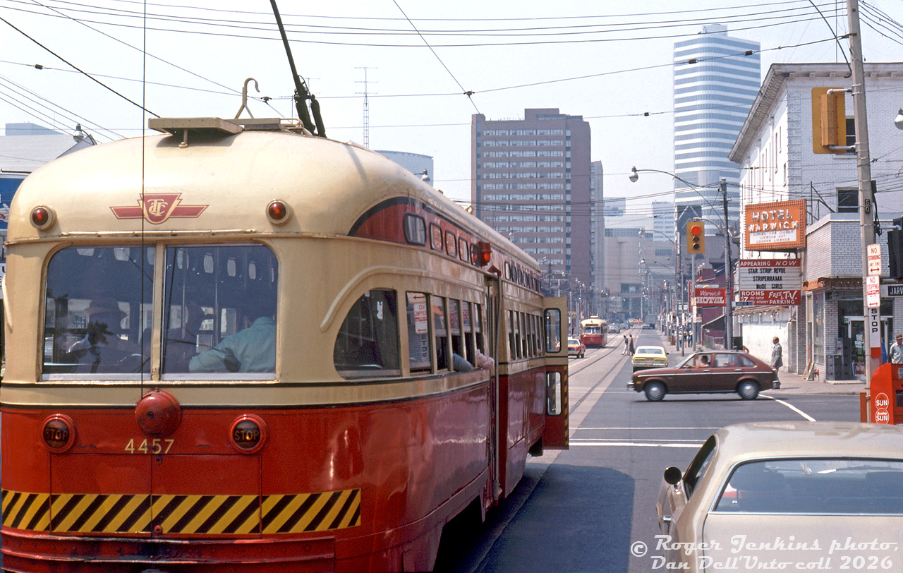 A somewhat unconventional streetcar photo: TTC PCC 4457 on Dundas Street East waits at the light westbound at Jarvis Street, doors open for any last-minute passengers. More than a few open windows with elbows poking out suggests it's a warm day, with other riders at the back going about reading their papers. The elevated left-hand vantage point might be from aboard one of those British double decker buses the TTC tried in tourist service around this time, sitting behind in traffic. Another PCC car approaches in the distance from around Church Street, and beyond that the towering Eaton Centre shopping mall and office tower at Yonge Street. The brown building in the middle is the Bond Place Hotel.But the real attraction here (in a matter of speaking) is the Warwick Hotel, another one of those seedy establishments of ill-repute in the general Yonge-Dundas area of Toronto. "Star Strip Revue", "Stripperrama", and "Nude Girls" advertise the kind of entertainment one may expect to witness inside, as well as rooms charging a $7 per person rate, rather than per hour. Other photos show retail shops sharing space on the ground level of the hotel included Lisa Variety at the corner, and some place called the "Nut Nest" (a nut shop, selling nuts). Aptly named.Research shows the Warwick Hotel was originally built as a hotel known as the Royal Cecil Apartments, owned by James Franceschini, an Italian immigrant who originally came to Canada from the old country before the war with no money and no English, but who picked up a pickaxe and went on to found and grow the Dufferin Construction empire. The Royal Cecil was originally just a hotel, and featured dance bands during the 1940/50's, but changed to its later questionable offerings by the 60's. City of Toronto Archives photos show the wrecking ball would come knocking on the Warwick in a few years, brought to the ground by Teperman Wrecking during 1980-81. The site would become home to a rather uneventful parking lot for many years to follow.Roger Jenkins photo, Dan Dell'Unto collection slide.