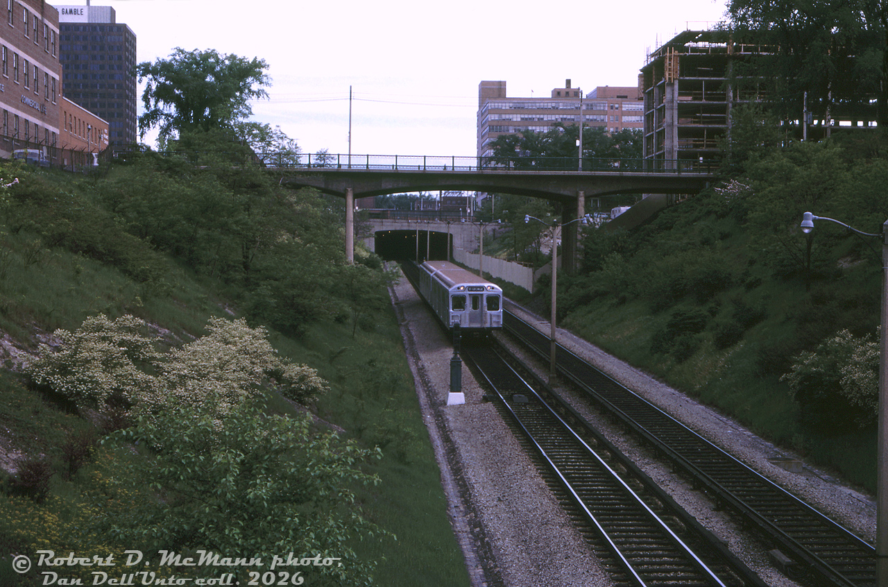 The first pair of TTC's brand-new Hawker Siddeley H1 subway cars (5336-5337, delivered to Davisville Yard earlier that month) operate on a special official train, heading southbound in the open-cut portion of the Yonge subway line at Jackes Avenue (taken looking north from Woodlawn Avenue).

According to notes by John Bromley and Robert McMann in an old UCRS issue, this was a test train preview run of the new H1 cars with 40 transit officials aboard, run on the morning of May 30th 1965 (departing 8:30am, with the only two cars delivered to Davisville) between Davisville Station and Union Station, followed up by breakfast at CP's Royal York Hotel. The pair of new cars had previously been testing on the line, and it was expected full consists of the new H1's would be in revenue service by mid-July 1965.

This section of the Yonge subway line between St. Clair and Summerhill stations would be completely covered over in the following years, as part of development of air rights over the subway line. Today, a very large apartment building resides over the space in the foreground, with greenspace over other portions.

Robert D. McMann photo, Dan Dell'Unto collection slide.