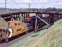 <br>
<br>
CP Rail 4207 East at the burnt Bee Bridge,
<br>
<br>
The CP bridge was repaired & re-opened... 
<br>
<br>
... about September 15, 2006 (per Mike Lockwood) CN destroyed their Bee Bridge by way of a shifted dimensional load closing Nichols Road as a through road –  today the south end remains an  un-maintained  municipal right of way – basically a farmer's lane.
<br>
<br>
 ' End of train device '  CP Rail van 434610 on tail end 942, 
<br>
<br>
near Belleville Sub mile 147, July 26, 1987 Kodachrome by S.Danko
<br>
<br>
Fun Facts:
<br>
<br>
Those open tri-levels: the Ford Oakville Assembly Plant manufactured from 1984 to 1994 the Ford Tempo (four door sedan & two door coupe) and Mercury Topaz vehicles.
<br>
<br>
And I recall the 1994 Tempo end of model year dealer pricing: $9,995. with a 2.3L four cylinder with 3 speed automatic.
<br>
<br>
 Other Oakville builds (and if you remember some of these, you are really …..): Edsel, Falcon, Comet, Custom 500, LTD, Lynx, Escort, Windstar, Freestar, Monterey, MKX and F series. Flex & MKT production ceased 2019 (Ford laid off 4,200), Nautilus produced until 2023, and Edge ceased 2024, then major 2025 re-tooling for the EV models (and you and me contributing CA$500. Million), then that plan canceled, now the Super Duty trucks (F250 F350) trucks are scheduled to commence production sometime in 2026. 
<br>
<br>
sdfourty
