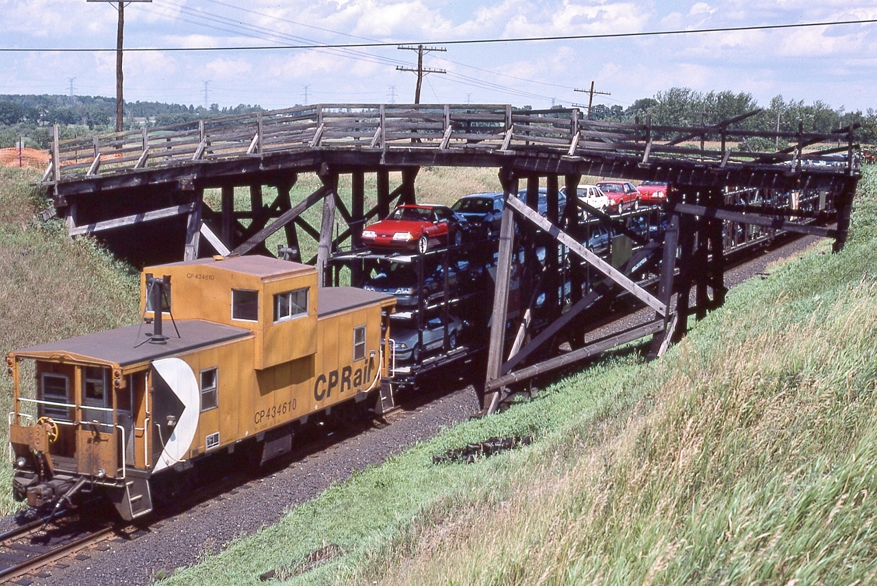 CP Rail 4207 East at the burnt Bee Bridge,


The CP bridge was repaired & re-opened... 


... about September 15, 2006 (per Mike Lockwood) CN destroyed their Bee Bridge by way of a shifted dimensional load closing Nichols Road as a through road –  today the south end remains an  un-maintained  municipal right of way – basically a farmer's lane.


 ' End of train device '  CP Rail van 434610 on tail end 942, 


near Belleville Sub mile 147, July 26, 1987 Kodachrome by S.Danko


Fun Facts:


Those open tri-levels: the Ford Oakville Assembly Plant manufactured from 1984 to 1994 the Ford Tempo (four door sedan & two door coupe) and Mercury Topaz vehicles.


And I recall the 1994 Tempo end of model year dealer pricing: $9,995. with a 2.3L four cylinder with 3 speed automatic.


 Other Oakville builds (and if you remember some of these, you are really …..): Edsel, Falcon, Comet, Custom 500, LTD, Lynx, Escort, Windstar, Freestar, Monterey, MKX and F series. Flex & MKT production ceased 2019 (Ford laid off 4,200), Nautilus produced until 2023, and Edge ceased 2024, then major 2025 re-tooling for the EV models (and you and me contributing CA$500. Million), then that plan canceled, now the Super Duty trucks (F250 F350) trucks are scheduled to commence production sometime in 2026. 


sdfourty