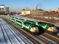 It was cold on Bathurst Street bridge that morning, very cold, but tolerable for photos of recently rebuilt VIA F40PH-2D 6400 making its <a href=https://www.railpictures.ca/?attachment_id=4210><b>first trip west on The Canadian</b></a> at 9am. As the minutes tick down to the top of the hour, other morning trains pass through, some inbound full of commuters and some outbound running empty. Two identical GO Transit "L10" consists, with F59PH units 543 and 564 both pushing, sit at Bathurst Street awaiting the light to head westbound back to Willowbrook Yard after completing their morning runs. The Quality Meat Packers abattoir was still "going at full ham" in the background, and would be for another few years until it closed down in 2014. Both of the remaining <a href=http://www.railpictures.ca/?attachment_id=41090><b>CP Parkdale Yard</b></a> spotlight towers can be picked out <a href=http://www.railpictures.ca/?attachment_id=41906><b>in the distance</b></a> around <a href=http://www.railpictures.ca/?attachment_id=8434><b>Strachan Avenue grade crossing</b></a>.<br><br>F59PH 543 would be another one of those F59's to leave and rejoin the roster (sold to AMT/exo as 1340, purchased back by GO as GOTX 582), while 564 would be one of the eight F59's retained and rebuilt for continued service.