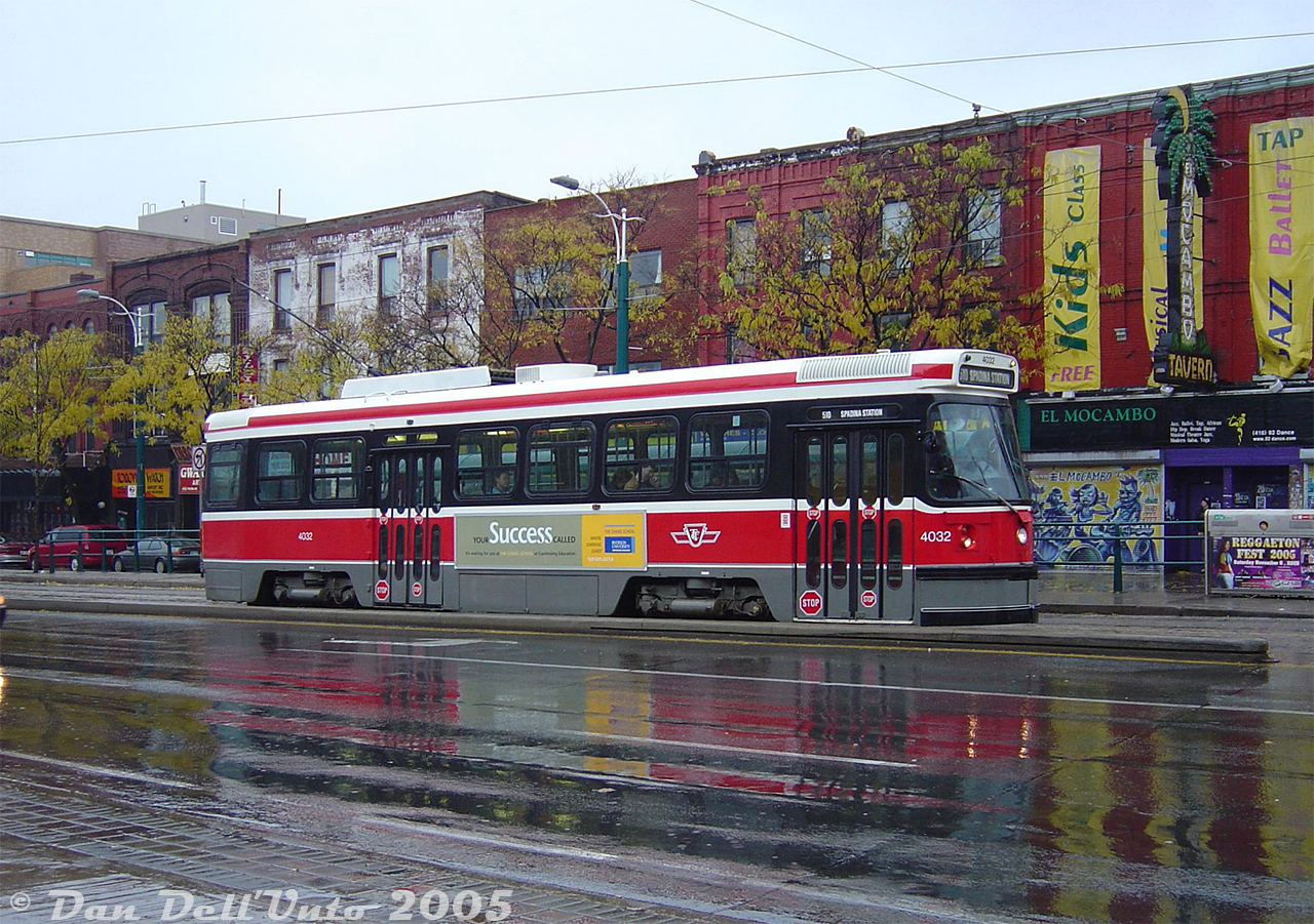 TTC CLRV 4032 heads northbound on a Route 510 Spadina run approaching College Street in the rain, passing "The El Mocambo", a longtime popular event venue in this area of Toronto whose classic neon sign marked this stretch of Spadina Avenue for decades. The wet glossy pavement adds a nice touch, even if the streetcar reflection is incomplete. The 4032's side ad advertises a successful career upon attendance of some place called Ryerson University, a name that the El Mocambo, despite all its recent ownership woes, has managed to outlive.