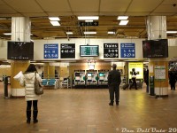 Everyone's favourite concourse: the GO concourse, in the basement of Toronto Union Station. A daily visit for many, the bane of their existence for some. Often smelly, crowded, noisy from <a href=https://www.railpictures.ca/?attachment_id=58219><b>trains rumbling above</b></a>, frequented by various solicitors, occasionally flooded ("Man the GO Ark!") and more often than not full of the intoxicating smell of Cinnabons behind pumped out nearby. <br><br> It's quieter down here tonight as evening commuters keenly watch the departure boards for the platform number of their GO train or bus trip to appear. Once some unknown higher power posts that magic number, it's off to the races through the maze of overhead walkways and staircases to get to the <a href=https://www.railpictures.ca/?attachment_id=56708><b>correct platform to board in time</b></a> (don't forget to stamp your 10-ride ticket or tap your Presto first, they don't like it when you forget). The "t.o.night" being advertised by the ticket machines was a briefly popular evening commuter newspaper at the time, with a basic glazing over of local/national news, pop culture and current events mixed in with ads, games/puzzles, horoscopes and a somewhat amusing commuter shoutout section (I think it published until 2014-ish). Signage advises commuters, many set in their paper ticket ways, of the benefits and usage of the new Presto farecard system that the GO and Accenture staff at 130 Adelaide spent much time developing. <br><br> The site of the original GO Transit commuter concourse was the present VIA arrivals area under the <a href=https://www.railpictures.ca/?attachment_id=59576><b>Great Hall</b></a> (which can be seen in the 1976 movie Silver Streak, thinly disguised for AM Road, complete with GO's ticket gates for pre-Proof-Of-Payment days). GO moved into this new concourse in 1979, built in the basement at the east end of <a href=https://www.railpictures.ca/?attachment_id=56888><b>Union Station</b></a> in what was once a postal handling facility. There were ticket gates here too (that can be seen in <a href=https://www.nfb.ca/film/after_axe/><b>NFB's "After the Axe"</b></a> film) until they were removed when GO changed to the POP system in the mid-late 80's. <br><br> The GO concourse was a time capsule in itself, featuring 1970's yellow, orange and brown earth tones, no shortage of round pillars supporting the trains rumbling just above the ceiling structure, and elevated walkway maze leading to various track platform stairways. Food vendors and aromas were in abundance, from the likes of McDonalds, Mr. Sub, Mmmuffins (Mmmmmmmmm), Dairy Queen, Mr. Sub and of course Cinnabon. The look and feel of the GO concourse remained largely unchanged until it was closed in mid-August 2015. GO passengers shifted to a new York Concourse, in order for the Bay Concourse to get a complete gutting and modernization. <br><br> The retro Toronto nostalgia buff types and social influencers on the 'grams would have have a field day down here if this relic in time still existed, alas, they'll have to get their kicks over at <a href=http://www.railpictures.ca/?attachment_id=59454><b>Spadina subway station</b></a> or <a href=http://www.railpictures.ca/?attachment_id=12120><b>Dupont</b></a> instead.
