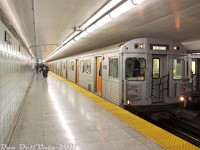 Operating on a westbound Bloor-Danforth run during rush hour, TTC 5916 leads a train of UTDC/Can-Car H6 subway cars westbound on the Bloor-Danforth line during a brief stop at Dufferin Subway Station. The open doors show off the distinctive orange doorways featured on the H6's. Another set of H6 subway cars sits on the adjacent platform, making their stop before continuing eastbound for Kennedy.