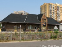 Another for the train station fans: the old GTR/CNR Brampton Station, taken from along Railroad Street looking at the platform view on a sunny afternoon. The brush wasn't as heavy that summer, affording a fairly clean shot compared to years past when the bushes and brush blocked the entire station view here. Back in 2002-2004 when I used to walk along Railroad Street from the bus terminal (the 9 Vodden was always good for a GM fishbowl ride downtown) to patronize The Little Train Shoppe nearby, the overgrowth was so bad it was hard to tell there was even a train station here, and I never bothered visiting it. But, I did note down things like the Amtrak/VIA International, and the GEXR with leased CN GP40-2LW's, even if the film camera was not at the ready.<br><br>This was the second Grand Trunk Brampton Station, built in 1907 as a replacement for the first when the fine growing farming and flower town of Brampton demanded increased train service from GTR, and a more modern station building. It has managed to stand the test of time through the GTR/CNR era (at the time of this photo, it would have been 100 years old) and now serves as the local downtown GO Transit/VIA Rail station.<br><br>At one point there were plans to build an entire Ryerson University medical school in the parking lot right next to the station, in the much-toted "Brampton Innovation District", but city council eventually gave them the old Bramalea Civic Centre (much to the ire of longtime Bramalea residents, and giving up Bramalea's newly renovated public library in the process), and the station area was spared that indignity. It looks about the same today, like a classic train station should, with an extra platform shelter or two blocking this view in the foreground.<br><br>A 1981 view by Bill Thomson: <a href=http://www.railpictures.ca/?attachment_id=22176><b>http://www.railpictures.ca/?attachment_id=22176</b></a>