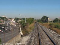 Another "on the GO" view, our train (GO Transit #252, Bramalea-Georgetown) has left <a href=https://www.railpictures.ca/?attachment_id=59712><b>Weston GO Station</b></a> a few minutes prior, and is cruising at speed southbound along the single-track Weston Sub on the approach to <a href=https://www.railpictures.ca/?attachment_id=59208><b>West Toronto diamond</b></a>. Out trailing cab car GO 201 has just passed over the double bridges in the Black Creek area of Weston, one for Black Creek Drive (Mile 6.45), another right after for Black Creek itself (Mile 6.40, in attractive CN light green paint). The CP MacTier Sub runs parallel on the right, mirrored with its own set of double bridges.
<br><br>
The intersection of Black Creek Drive and Weston Road is visible on the left, with Weston snaking through the creek valley. A pair of Detroit-powered 1991 TTC Orion V buses on the Route 89 Weston are climbing the hill up from Black Creek to Rogers Road, regulars on the route at the time. On the right are some of the last remains of Kodak Canada's Mount Dennis plant under demolition (one building was saved, and is now the site of the TTC/GO/UPX Mount Dennis transit station). About three extra tracks have since been added to the CN (Metrolinx) side, requiring additional bridge spans to be installed.