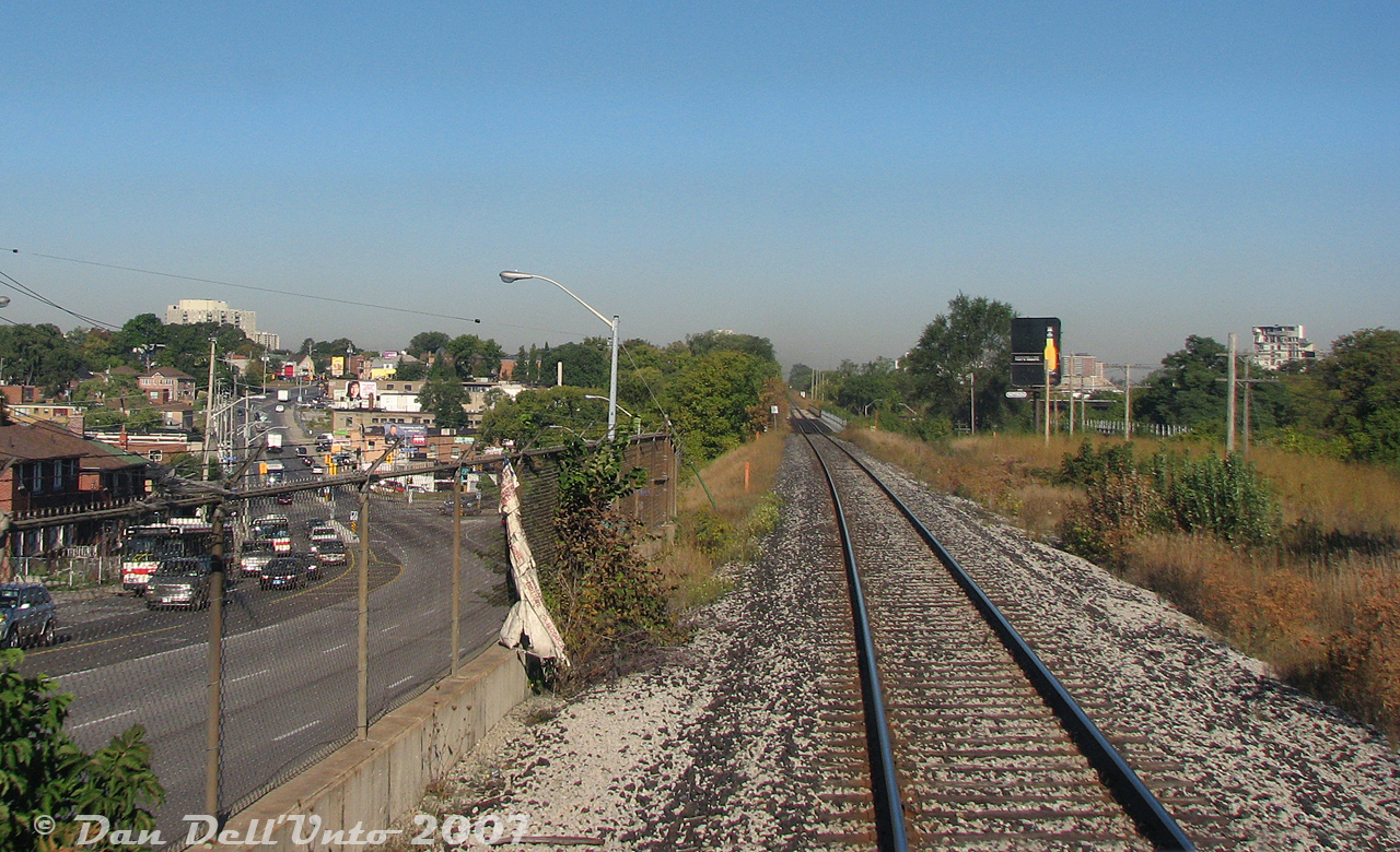 Another "on the GO" view, our train (GO Transit #252, Bramalea-Georgetown) has left Weston GO Station a few minutes prior, and is cruising at speed southbound along the single-track Weston Sub on the approach to West Toronto diamond. Out trailing cab car GO 201 has just passed over the double bridges in the Black Creek area of Weston, one for Black Creek Drive (Mile 6.45), another right after for Black Creek itself (Mile 6.40, in attractive CN light green paint). The CP MacTier Sub runs parallel on the right, mirrored with its own set of double bridges.

The intersection of Black Creek Drive and Weston Road is visible on the left, with Weston snaking through the creek valley. A pair of Detroit-powered 1991 TTC Orion V buses on the Route 89 Weston are climbing the hill up from Black Creek to Rogers Road, regulars on the route at the time. On the right are some of the last remains of Kodak Canada's Mount Dennis plant under demolition (one building was saved, and is now the site of the TTC/GO/UPX Mount Dennis transit station). About three extra tracks have since been added to the CN (Metrolinx) side, requiring additional bridge spans to be installed.