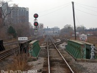 Another shot from the best seat on the train: <a href=https://www.railpictures.ca/?attachment_id=59667><b>riding in the back</b></a> of GO Transit cab car 201 on late morning train #252 (Georgetown line, Bramalea-Union), we've just rattled over the crossover switch between CN's Weston Sub mainline tracks and over the steel girder bridge span over busy Queen Street West at CN Parkdale, click-clacking down the stick rail on the home stretch to Toronto Union Station downtown. We're on the south mainline track, with the north mainline visible to the right, along with the start of the CN Newmarket Sub (GO Barrie-line trains) branching off at the switch by the sign. The "last minute" crossover track here let Barrie-line GO trains use the south track of the Weston Sub to/from Parkdale.<br><br>On the left are CP's two Galt Sub mainline tracks (GO Milton line), that at the time were completely separate all the way to West Toronto and weren't connected with the Weston Sub at all. This location has the mileboard for "CP Dundas" (after Dundas Street, further north at Mile 3.5 CP Galt Sub) however this location itself was still known as CP Parkdale in official timetables (Mile 2.3), but with nothing to really here of importance to note anymore. There was a really old wooden relic of a CP Parkdale sign that used to be around Lansdowne Ave in the distance, with a modern sign lazily nailed over it. Hopefully it went to a good home when Metrolinx removed it.<br><br>How the mighty have fallen: this part of Toronto was once home to not one but two decent-sized railway stations (<a href=http://www.railpictures.ca/?attachment_id=35185><b>CN</b></a> and <a href=http://www.railpictures.ca/?attachment_id=36087><b>CP Parkdale</b></a>, both demolished), small and medium-sized <a href=http://www.railpictures.ca/?attachment_id=53581><b>yards</b></a> and associated facilities for both railways (all removed), and lots of industrial sidings and spurs for local factories and industries around Parkdale and Liberty Village (all gone). Parkdale railway-wise in 2007 had been reduced to just an interlocking plant where the <a href=http://www.railpictures.ca/?attachment_id=44939><b>Newmarket Sub</b></a> (Mile 2.4) split off from the Weston Sub (Mile 2.5), a far cry from the days of <a href=https://www.youtube.com/watch?v=eAzNkDLRCao><b>Stompin' Tom Conners</b></a> hanging out on the platforms..<br><br>Around 2008, the (Metrolinx/CN) Parkdale interlocking was moved north closer to Lansdowne underpass to facilitate rebuilding the underpasses and Duffern Street, in order to eliminate the "Dufferin Jog" at Queen Street (continuing Dufferin Street below the rail bridges instead of its previous disjointed alignment). New modern signals went in replacing the old ones, some track realignments took place around this time with the unused spans to keep rail traffic flowing as the bridge spans were rebuilt or reconditioned, and several new spans added. More recent track diagrams now show Metrolinx has a total of 8 bridge spans here: 4 for active mainline tracks (x1 Galt Sub, x3 Weston Sub) as well as 4 extra spans for future track additions as-needed (x2 for future planned extensions of the Newmarket Sub, x2 for adding extra Weston or Galt Sub mainline tracks back).