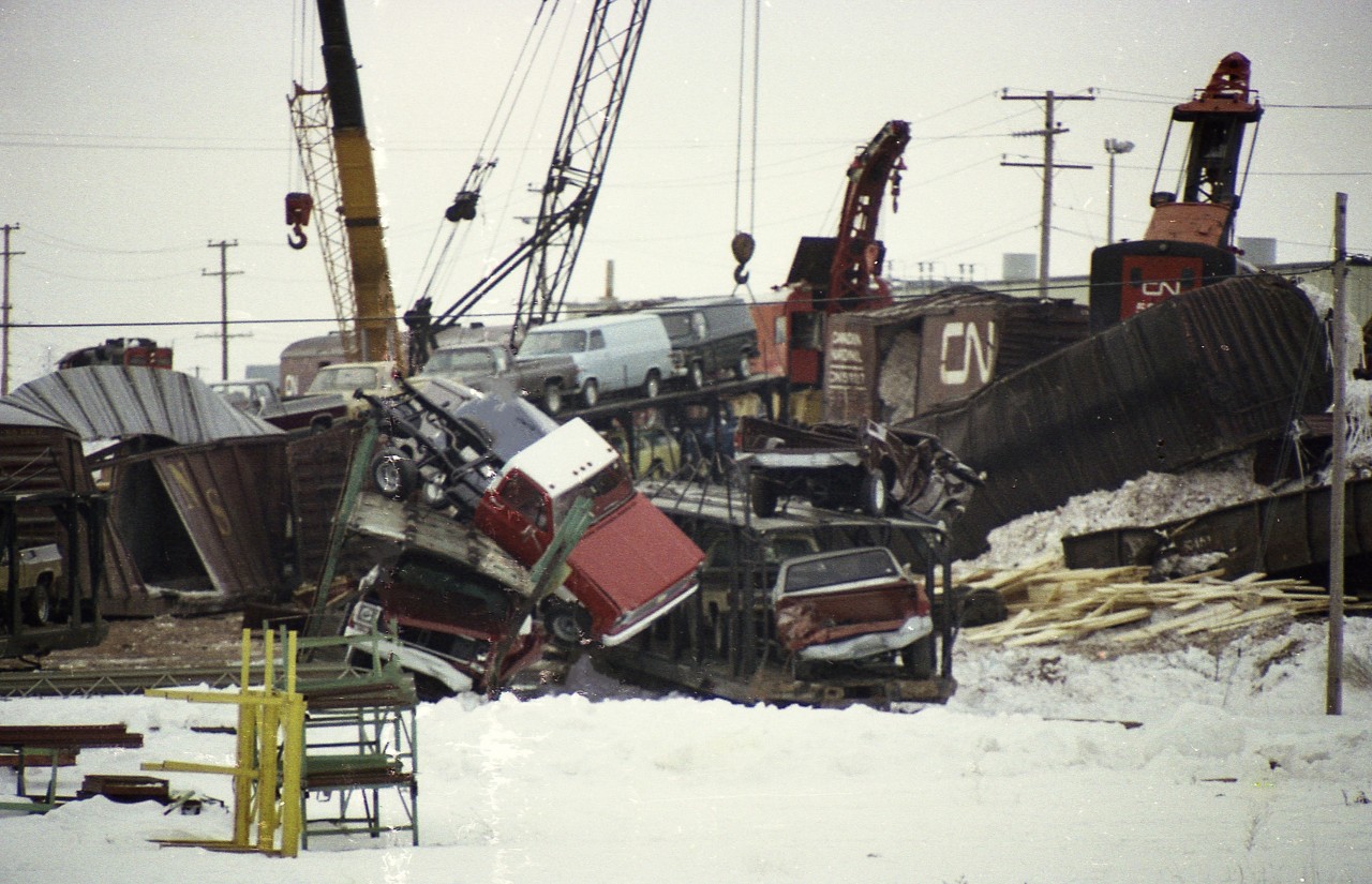 To my knowledge nobody has posted any photos from the Burlington "Mainway" wreck of early January 1977. So then, here's one. This negative was in rough shape, but still fared better than the subjects.
This was a Toronto to Fort Erie train. Thirty-seven cars of an 87 car train went on the ground January 19th when a car carrying sulphur suffered wheel seizure. Lumber, sulphur, vehicles and scrap were scattered all over the place in this derailment that happened between Walker's Line and Guelph Line. Damage estimated at more than $2 million.
For those who would like to know, the engineer was John Misener of Niagara Falls, head brakeman was Ray Beroud of Stevensville. Terry Illingworth of Fort Erie and another (unidentified) were in the caboose.
Two of the hooks on the job I made note of were CN 50014 and 50019. Work train led by CN 4585.