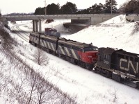 Another one of those typical blah winter days, but I found the desire to get out trackside anyway. From the hillside at the Junction I caught a going-away shot of VIA' #75 which I grabbed because I didn't know CN 3107 was fourth unit until the train was going by. Power is all still in CN colours: 6786, 6860, 6767 & 3107. What is interesting is a couple of MoW cars on the old steam helper track, now just a spur. I do not ever recall cars being pushed so far up toward the end of track.
This is the York Blvd bridge, and the train is approaching Ham West. The RR structure in the top upper left was torn down not long after this shot was taken.