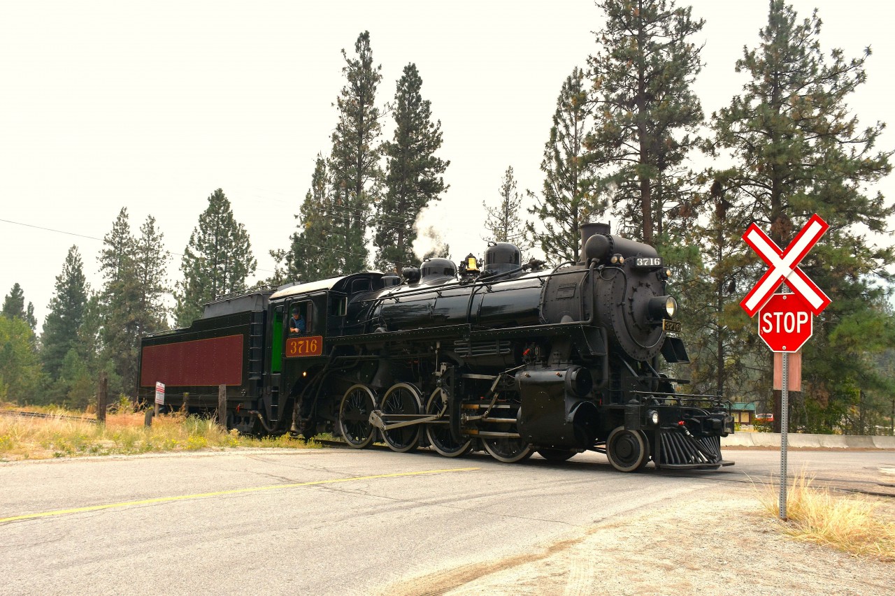 Kettle Valley's steam engine 2-8-0 #3716 is shown here at the closest crossing to the enginehouse and ticket area as it moves to connect with its excursion train to take the enthusiastic riders (inc.me!) on a leisurely 10 mile ride down thru prairie valley to Faulder and back.
As I am typing this up, one of British Columbia's out of control wild fires is threatening this operation. The city of Summerland is under evacuation orders and I understand the railroad has moved as much of its equipment as possible down the line to hopefully get out of harm's way.
It is an extremely serious situation.  We can only hope that the railroad and the city can somehow be spared.
