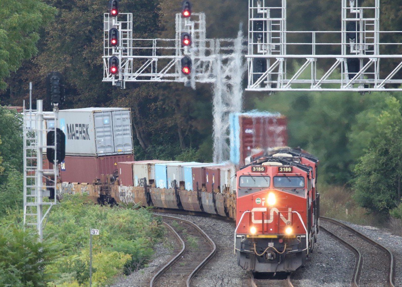 Having set out from Fort Erie, CN422, lead by 3186 ( GE ET44AC )  is chugging her way to Toronto's Macmillan Yard. As she passed under the pedestrian overpass one could certainly feel the heat spewing out of the exhaust. Making up the power along with 3186 was
8318  EMD SD75I ACC
3159 GE ET44AC
3140 GE44AC